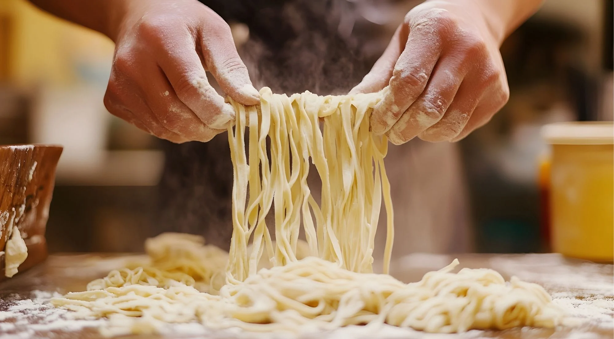 Chef pulling fresh pasta noodles by hand in a cloud of flour in a Naples kitchen